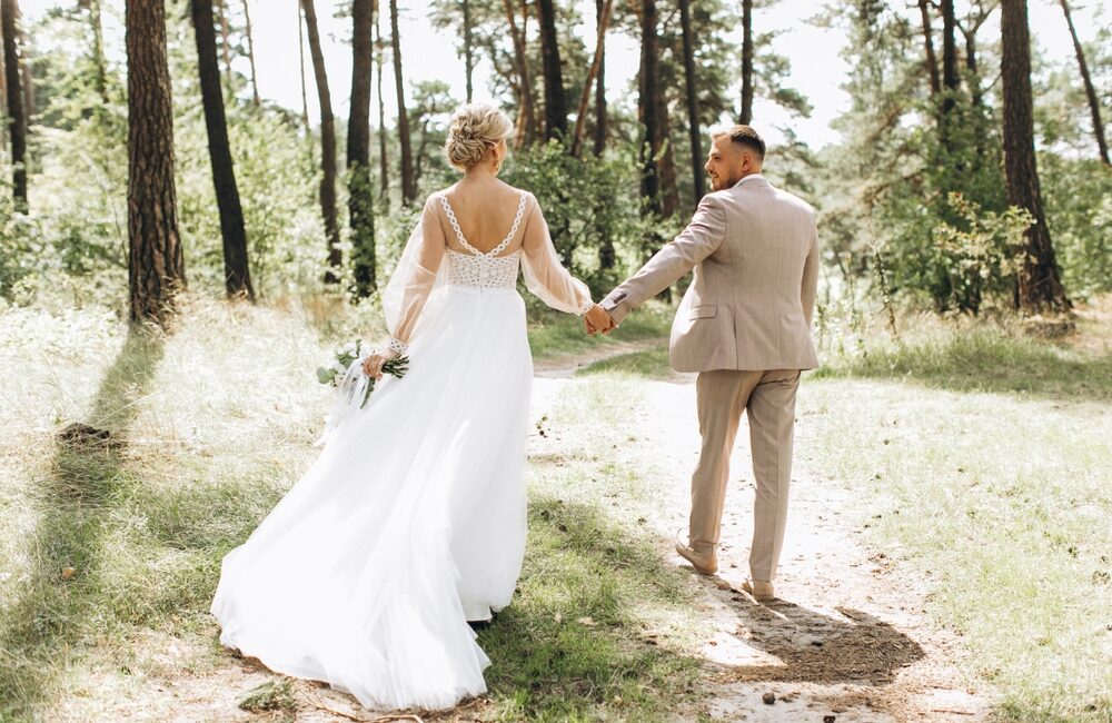 Wedding,Couple,Bride,And,Groom,Walk,Hand,In,Hand,Through